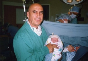 Alexander holding his new born son in the delivery room